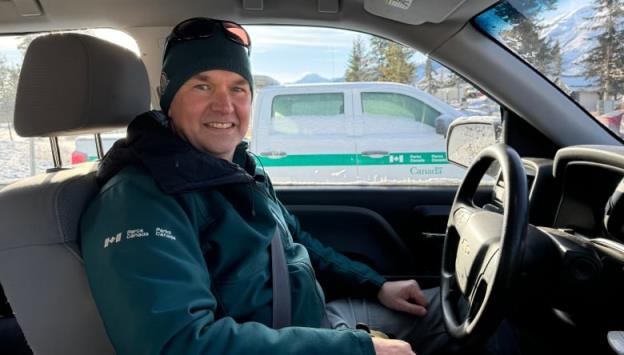 A Parks Canada official sits inside a work truck.