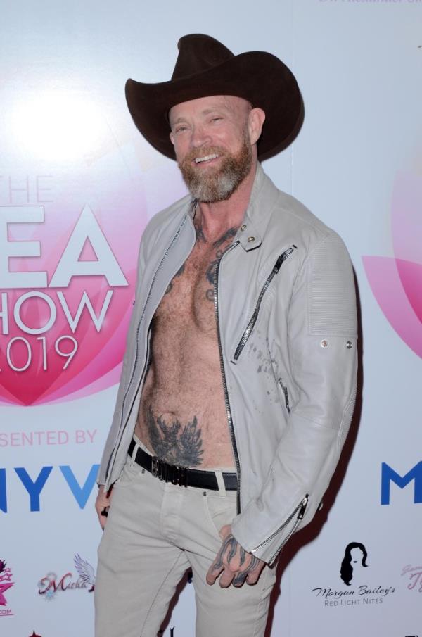 Buck Angel standing on a red carpet at an event.