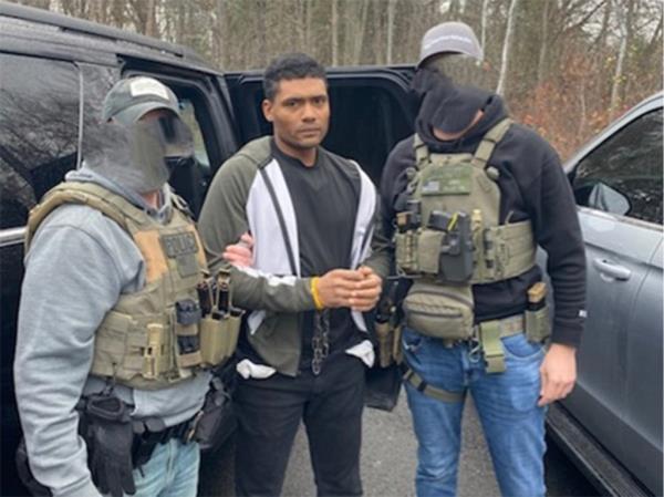 Alexandre Romao De Oliveira is held by two ICE agents following his arrest.