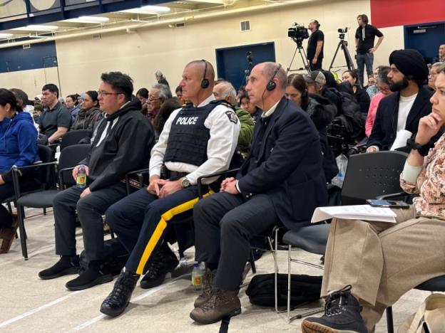 Two RCMP staff sitting amo<em></em>ngst crowd