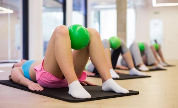 Women in a fitness class using workout balls for a pelvic floor exercise