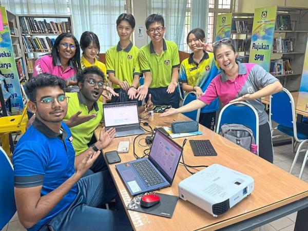 From left: Niraj, Ravindran, teacher Suganthi, Tan, Loo, Lee, Gan and teacher Chan showcasing a device designed to aid stroke patients in recovery and rehabilitation. — RAVINDRAN SURANDRAN